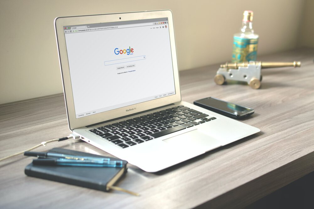 An image of a laptop opened on the table top, focusing on the concept of Online Reputation Management software , primarily around Search Engine.