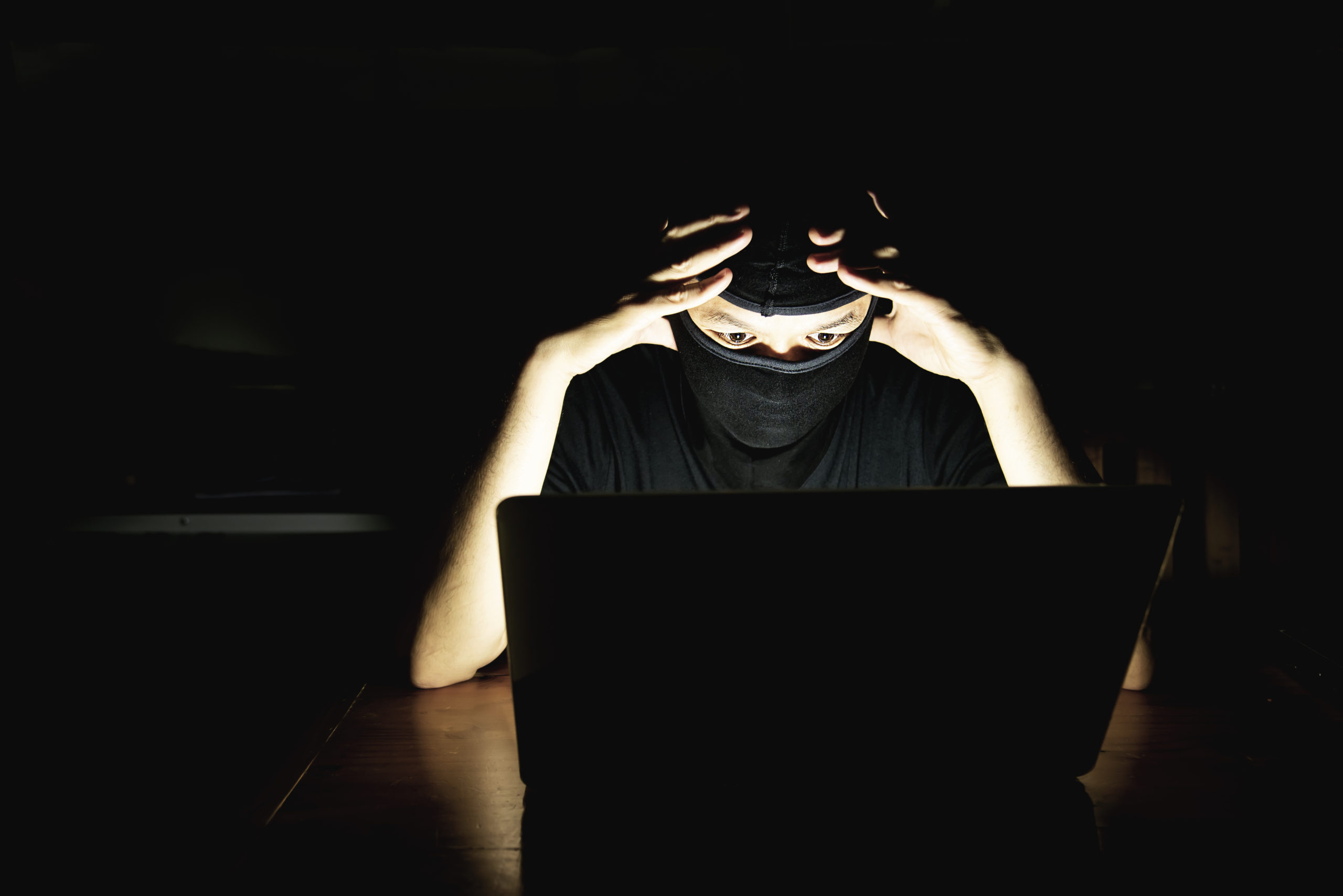 computer-hacker-doing-his-job-with-laptop-computer-dark-room