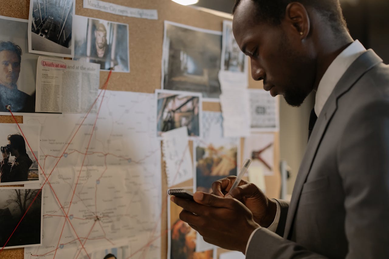 man-in-gray-suit-taking-down-notes