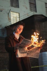 boy reading a burning paper