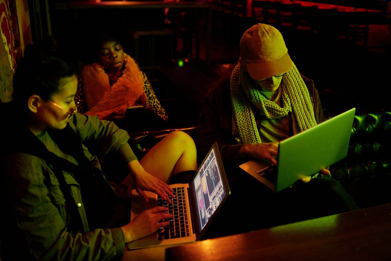 hackers-with-laptops-sitting-in-dark