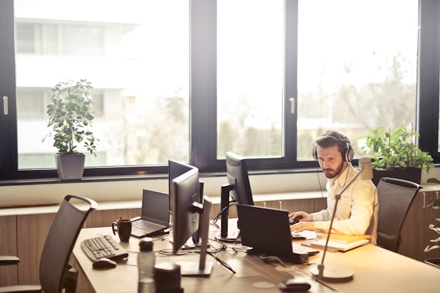 man-with-headphones-facing-computer-monitor