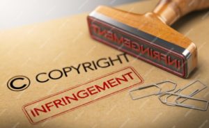 3D illustration of rubber stamp with the words copyright and infringement over kraft paper background, Concept of intellectual property