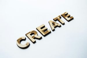 The word “create” in bold letter made of wood.