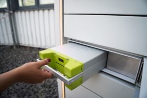 A person inserting an electrical box into a control unit.