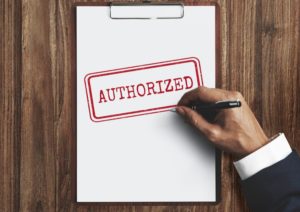 Document with “Authorized” stamped in red placed on a wooden table