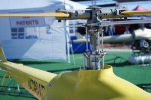 View of a helicopter's main rotor system at an outdoor event, showcasing engineering intricacies.