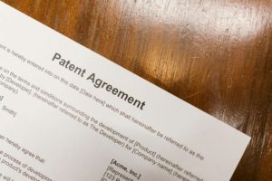 Detailed close-up of a patent agreement document on a polished wooden table